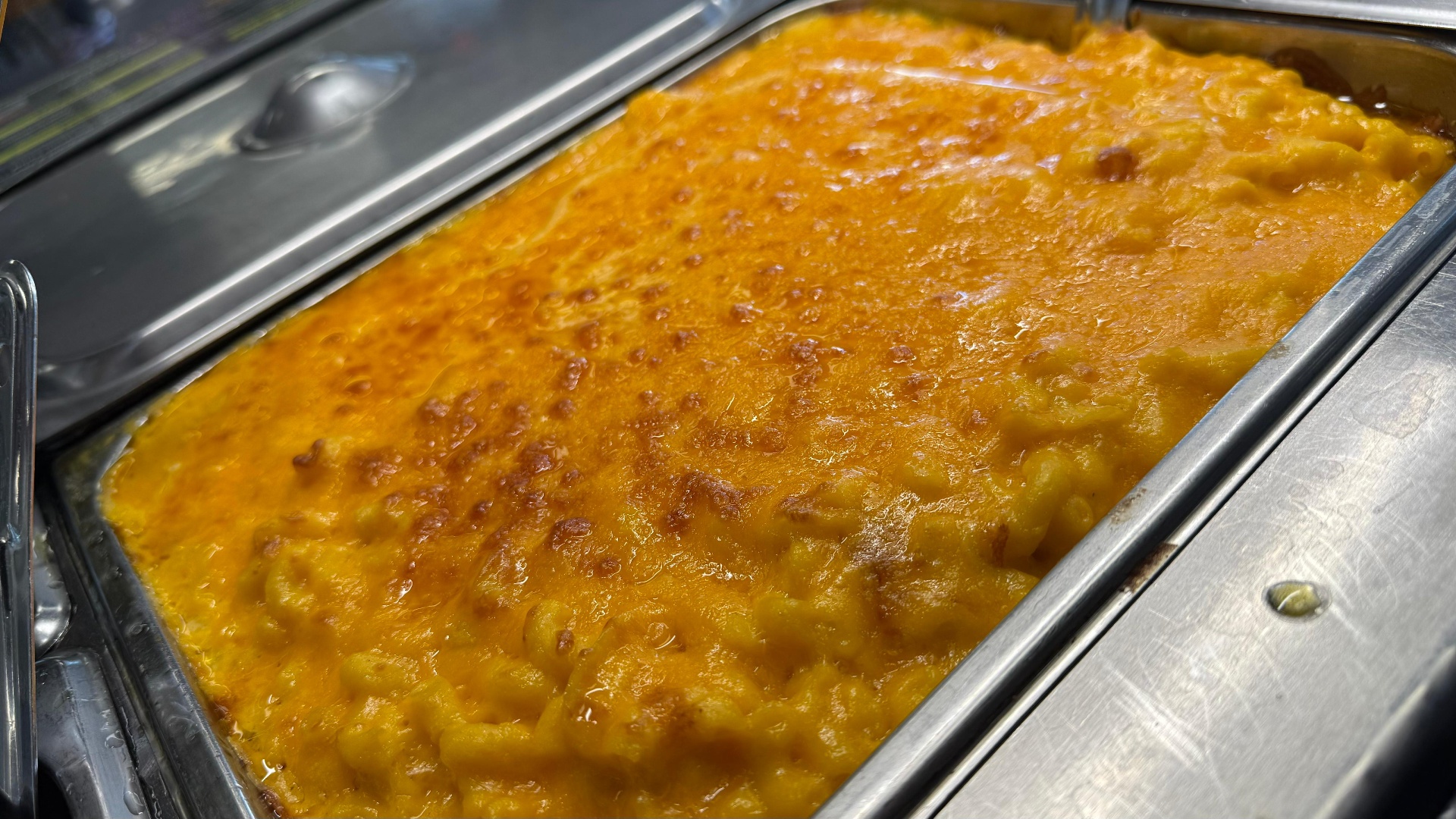 Pan of golden baked Caribbean mac and cheese with crispy cheddar top