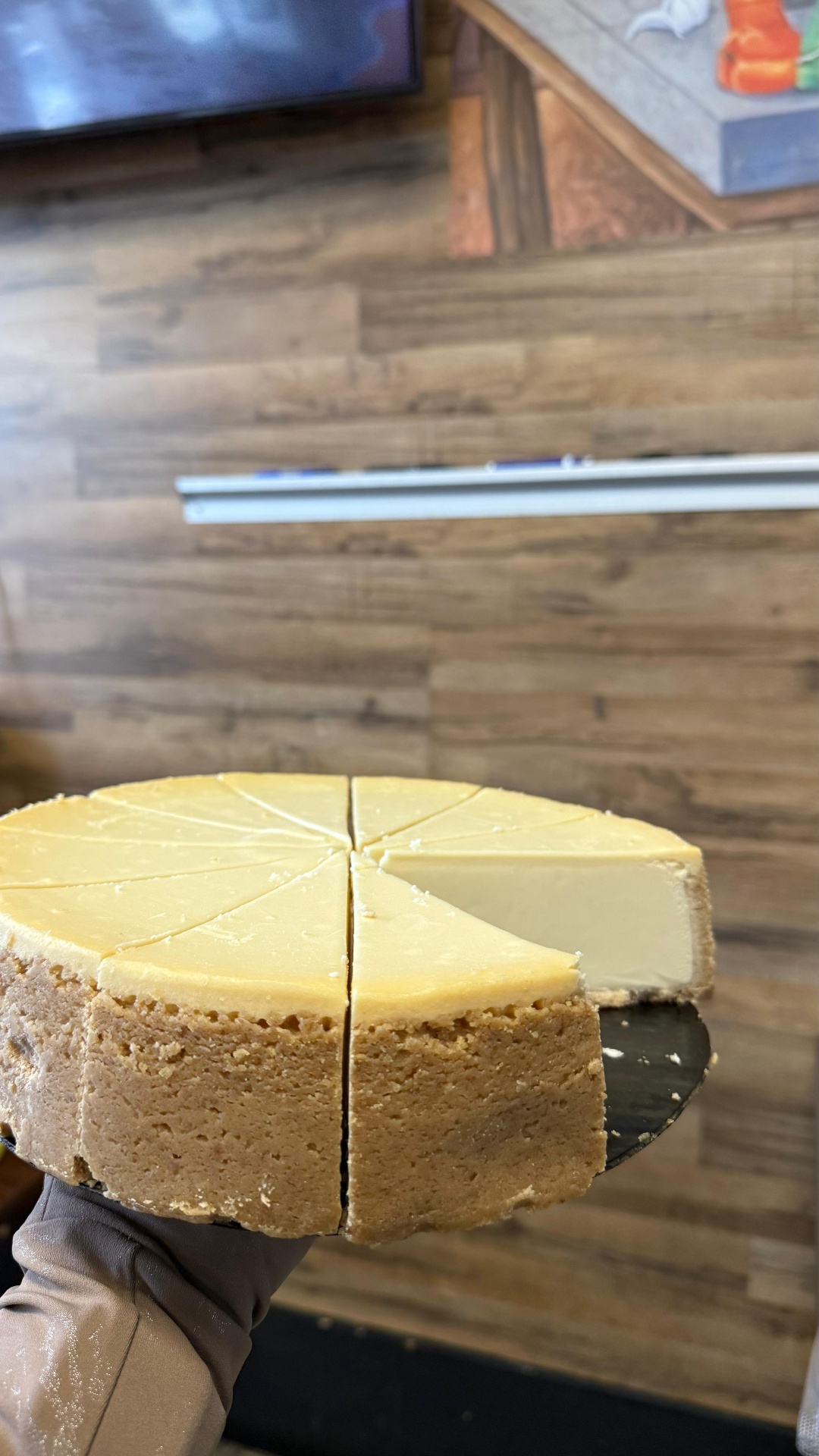 Whole house-made cheesecake sliced into wedges with one piece pulled out