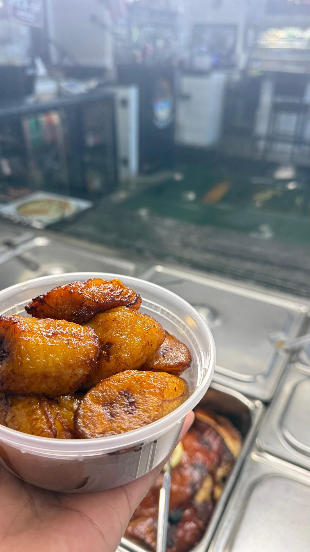Cup of golden caramelized sweet plantains over the Caribe steam table