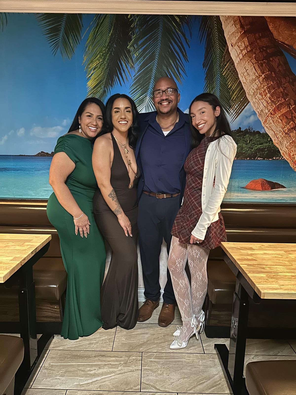 Maggie, Fermin and their daughters by the tropical beach mural