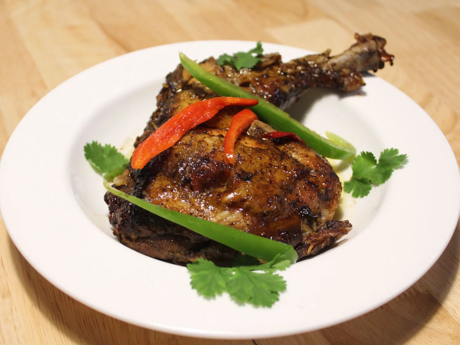 Jerk chicken with crispy skin, peppers, and cilantro at Caribe
