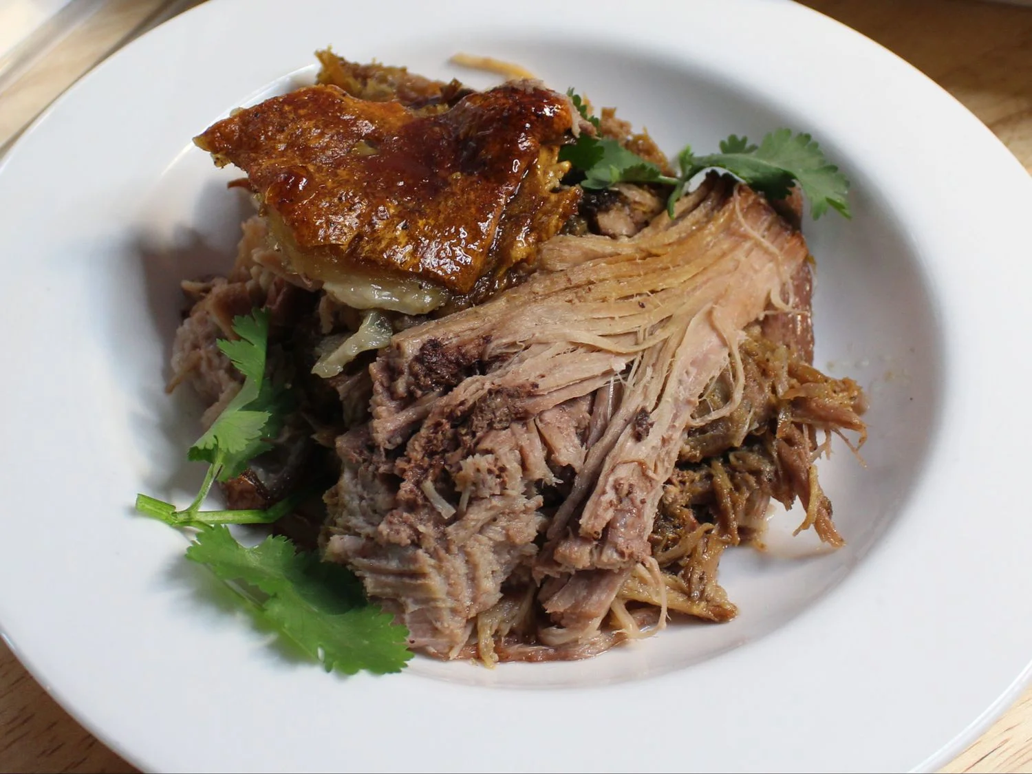 Slow-roasted pernil with crispy skin and tender shredded pork at Caribe